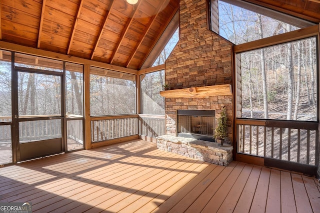 unfurnished sunroom with a fireplace, lofted ceiling with beams, and wooden ceiling