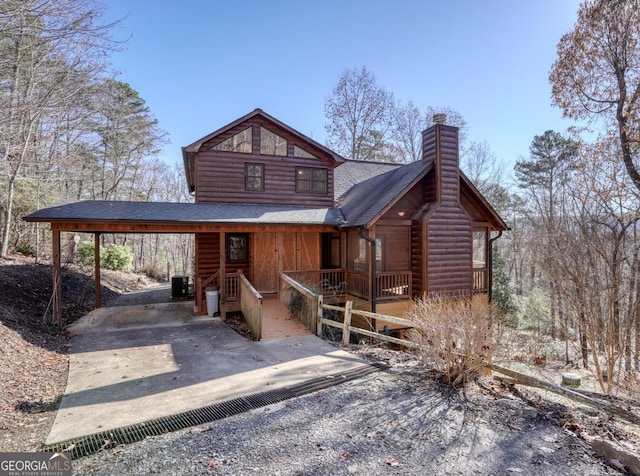 view of front of property featuring a carport, cooling unit, and a porch