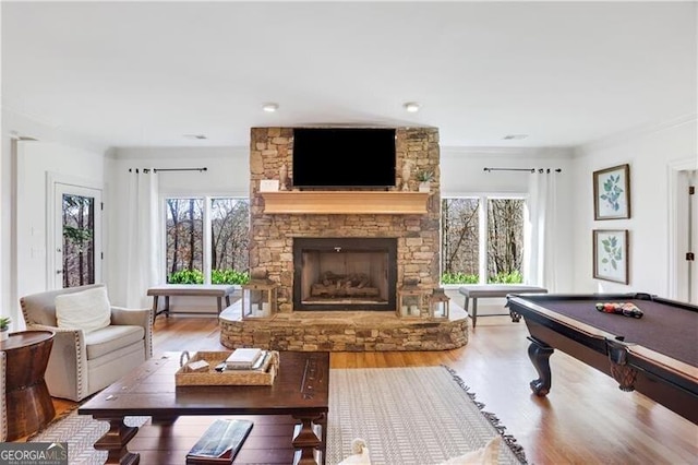 playroom featuring a wealth of natural light, billiards, hardwood / wood-style floors, and a fireplace