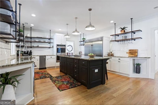 kitchen with white cabinets, tasteful backsplash, and appliances with stainless steel finishes