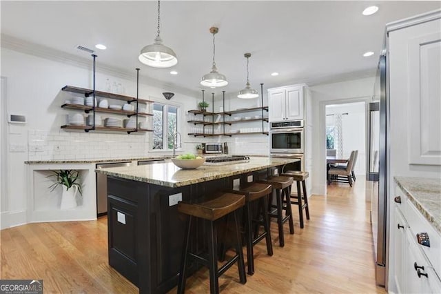 kitchen featuring a kitchen island, a healthy amount of sunlight, light hardwood / wood-style floors, and white cabinets