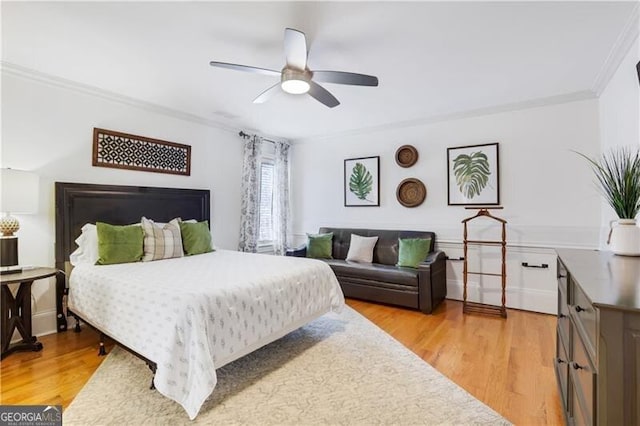 bedroom featuring light wood-type flooring, ceiling fan, and crown molding