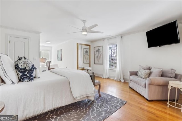 bedroom featuring ceiling fan, hardwood / wood-style flooring, and ornamental molding