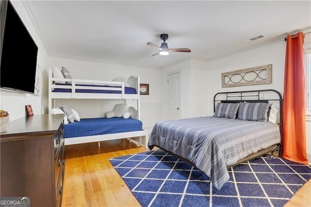 bedroom with ceiling fan, hardwood / wood-style flooring, and crown molding