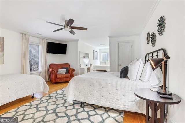 bedroom featuring ceiling fan, wood-type flooring, and crown molding