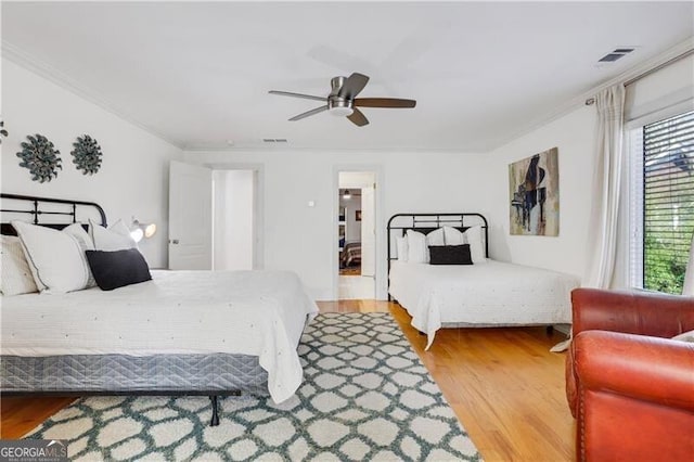 bedroom featuring ceiling fan, wood-type flooring, and crown molding