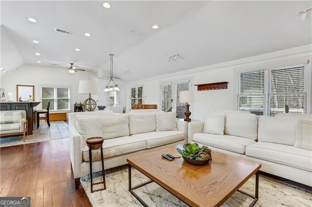 living room with lofted ceiling, ceiling fan, and wood-type flooring