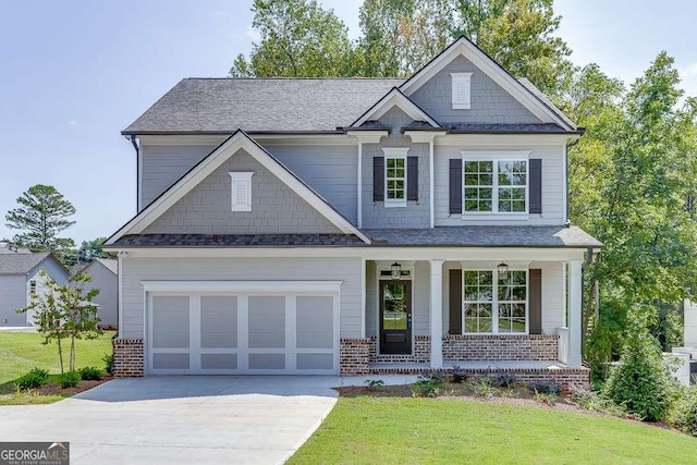 craftsman-style house featuring a front lawn, a porch, and a garage