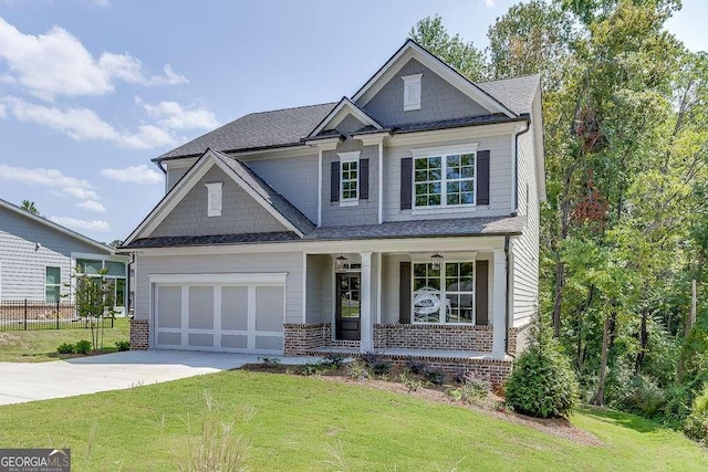 craftsman house featuring covered porch, a garage, and a front lawn