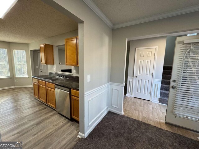916 Brisley Cir, Hampton, GA 30228 - kitchen featuring sink, stainless steel dishwasher, ornamental molding, a textured ceiling, and light hardwood / wood-style floors