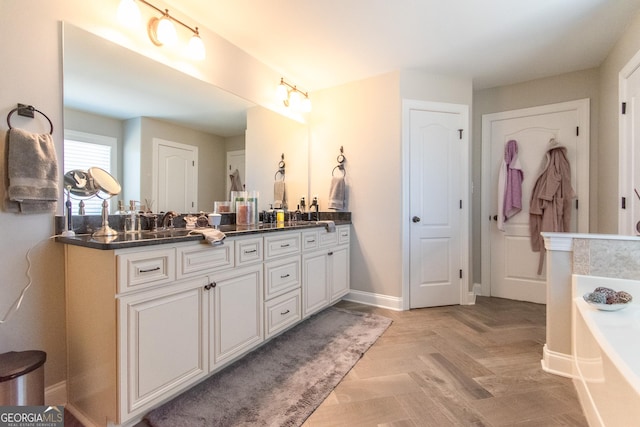 bathroom with a bathing tub, vanity, and parquet flooring