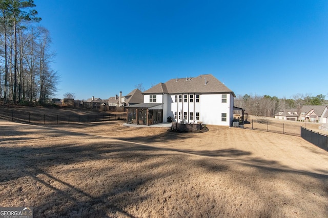 back of property featuring a sunroom and a lawn