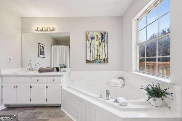 bathroom with vanity and tiled bath