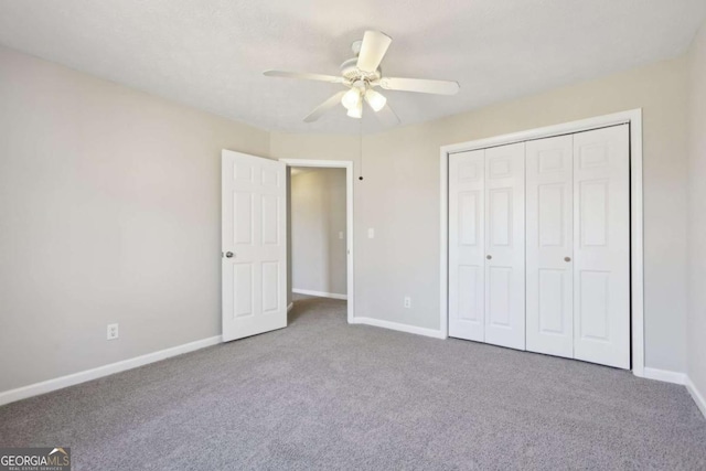 unfurnished bedroom featuring carpet, a closet, and ceiling fan