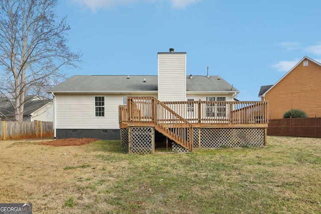 back of property with a deck and a lawn