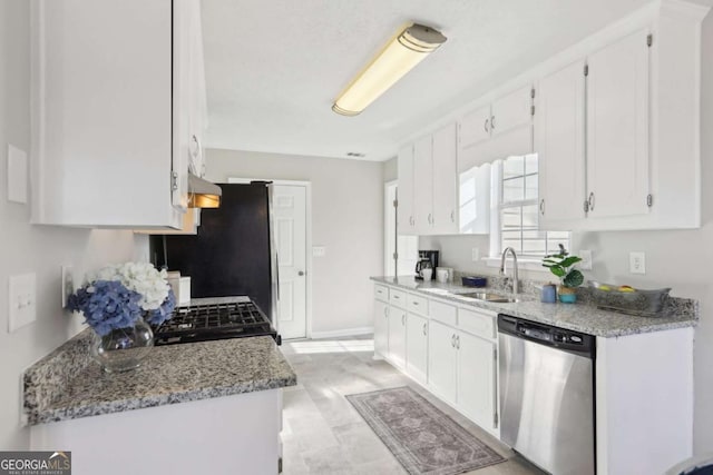 kitchen with sink, light stone counters, stainless steel dishwasher, fridge, and white cabinets