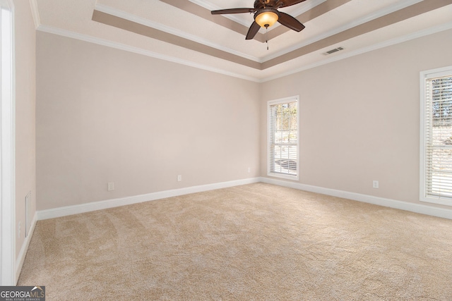 carpeted spare room with crown molding, ceiling fan, and a tray ceiling