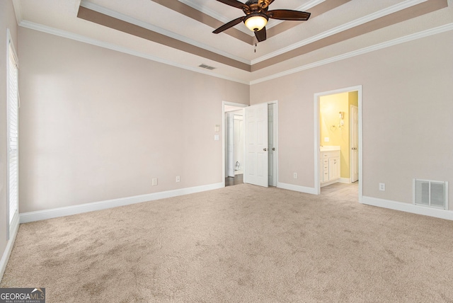 carpeted spare room featuring a raised ceiling, ornamental molding, and ceiling fan