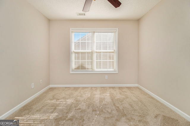 carpeted empty room featuring ceiling fan and a textured ceiling