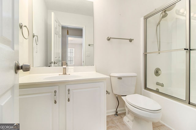 full bathroom with tile patterned flooring, bath / shower combo with glass door, vanity, and toilet