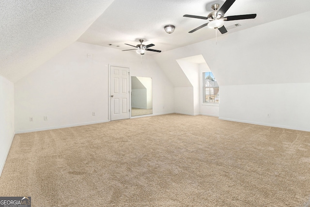 bonus room with ceiling fan, vaulted ceiling, a textured ceiling, and carpet