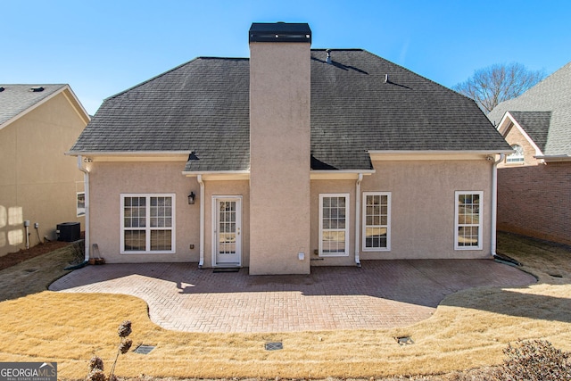 back of house featuring a lawn, central AC, and a patio area