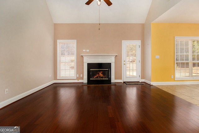 unfurnished living room featuring ceiling fan, lofted ceiling, and dark hardwood / wood-style floors