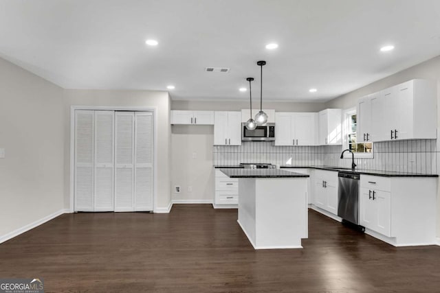 kitchen featuring decorative light fixtures, white cabinetry, and appliances with stainless steel finishes