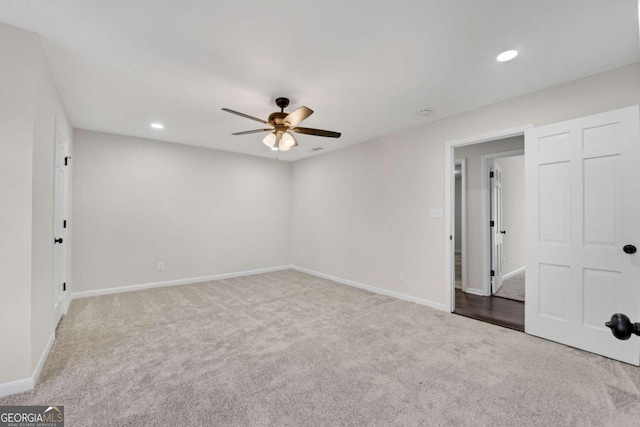 spare room with light colored carpet and ceiling fan