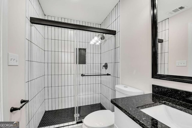 bathroom with an enclosed shower, vanity, and toilet