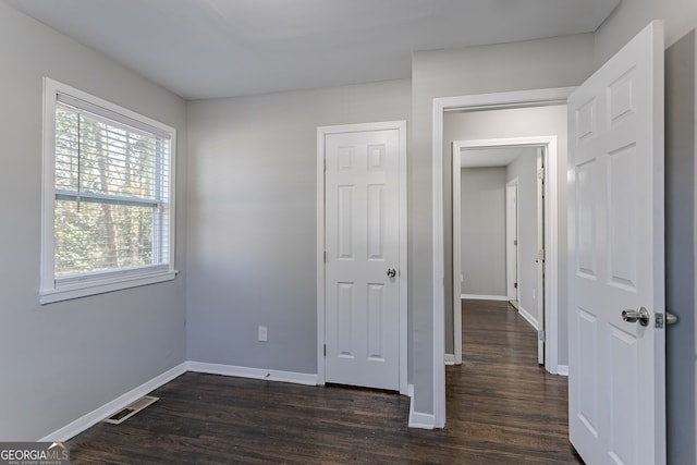 unfurnished bedroom with dark wood-type flooring