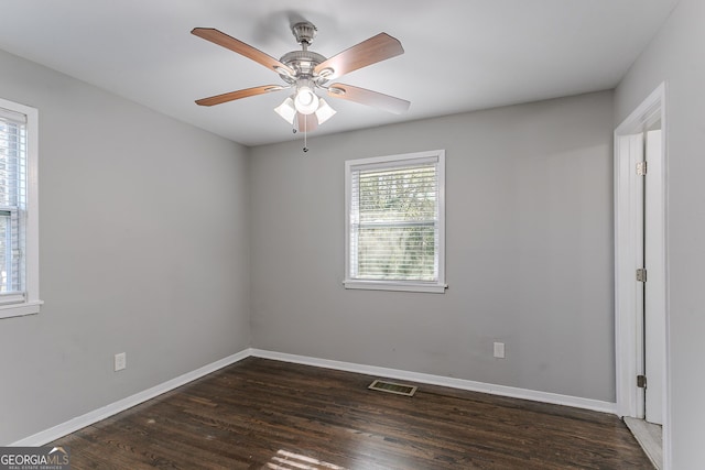 spare room with dark wood-type flooring and ceiling fan