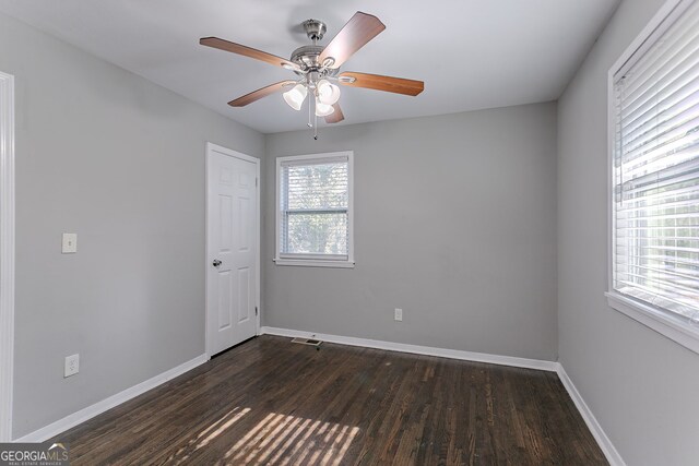 empty room featuring ceiling fan and dark wood-type flooring