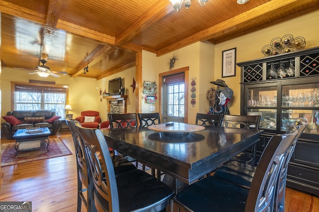 dining area featuring hardwood / wood-style floors, beam ceiling, ceiling fan, and wood ceiling