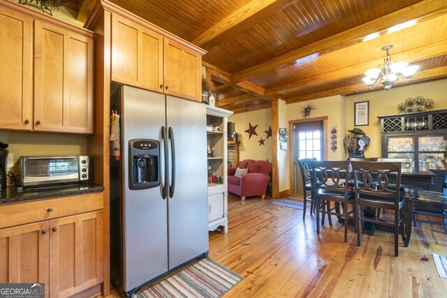 kitchen featuring hanging light fixtures, light hardwood / wood-style flooring, beamed ceiling, stainless steel fridge, and a chandelier