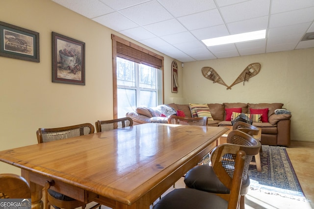 dining space with a paneled ceiling