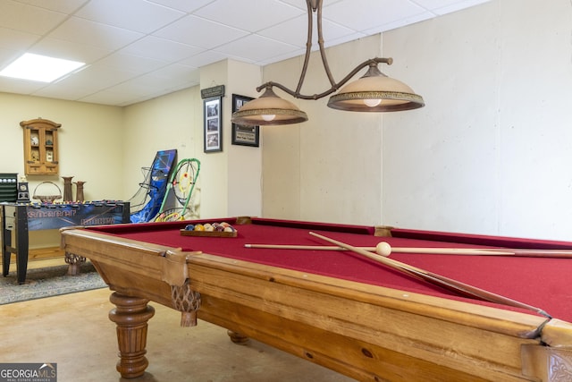 game room with a paneled ceiling, concrete floors, and billiards