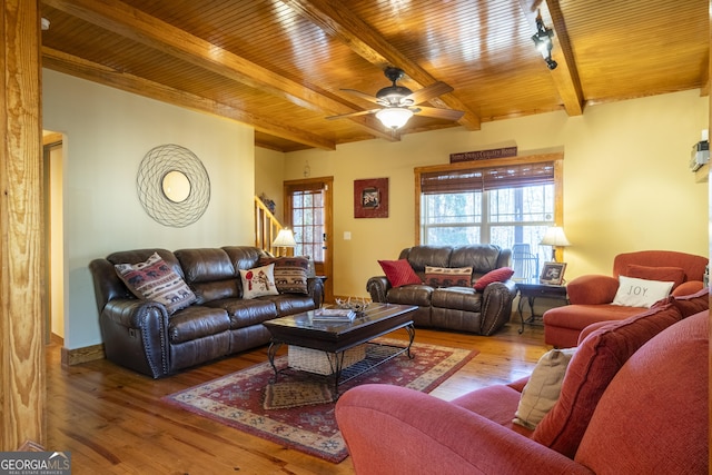 living room featuring ceiling fan, beamed ceiling, wooden ceiling, and hardwood / wood-style flooring