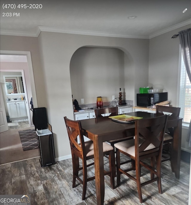 dining space featuring dark hardwood / wood-style floors and ornamental molding