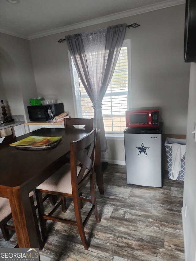 dining area with wood-type flooring and crown molding