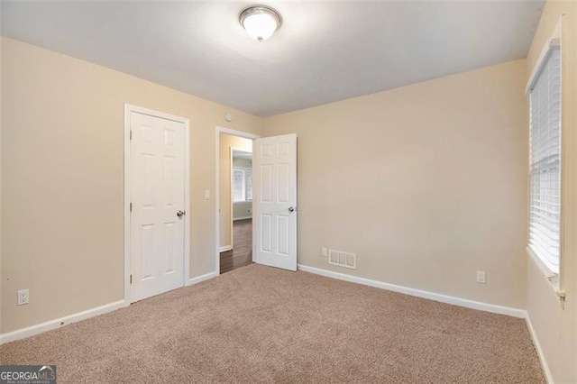 unfurnished bedroom featuring carpet flooring and a closet