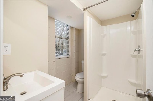 bathroom featuring tile patterned floors, a shower, sink, and toilet