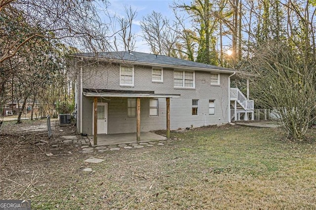 rear view of property featuring a lawn and a patio area