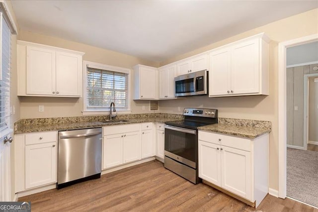 kitchen featuring stone countertops, white cabinetry, sink, and appliances with stainless steel finishes