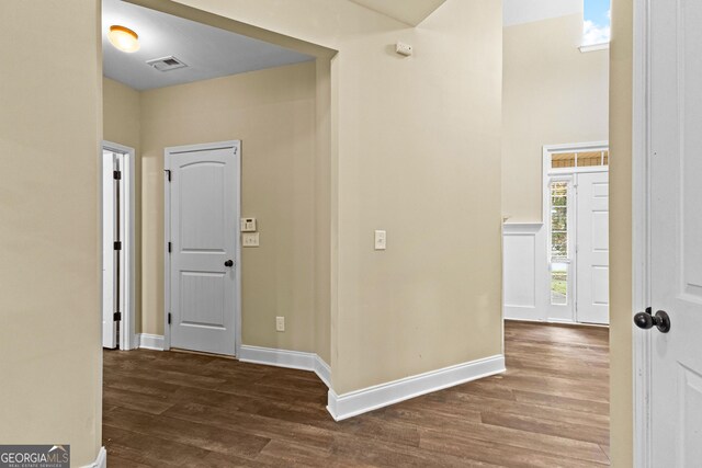 corridor featuring a wealth of natural light and dark wood-type flooring