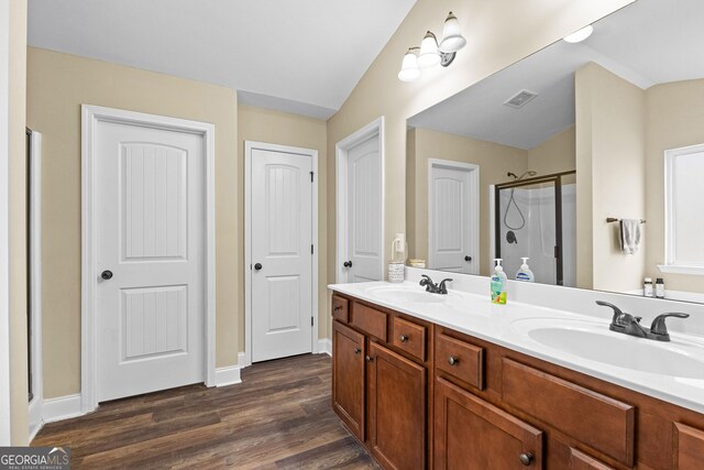 bathroom featuring hardwood / wood-style floors, vanity, a shower with door, and lofted ceiling