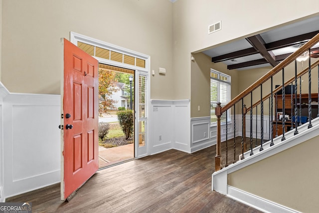 entryway featuring beam ceiling, dark wood-type flooring, a healthy amount of sunlight, and coffered ceiling