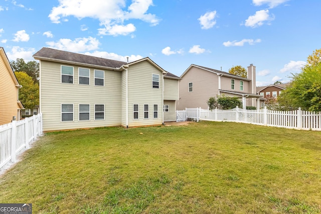 rear view of property featuring a lawn