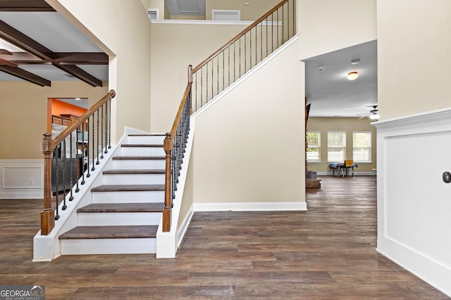 stairs featuring beamed ceiling, hardwood / wood-style flooring, ceiling fan, and coffered ceiling