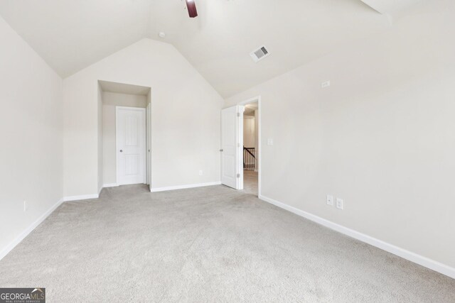 unfurnished bedroom with ceiling fan, light carpet, and vaulted ceiling